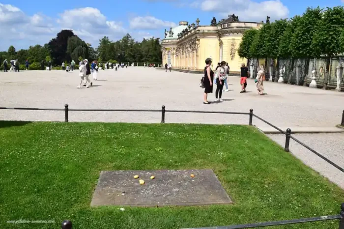 Grab Friedrichs des Großen vor Schloss Sanssouci in Potsdam mit abgelegten Kartoffeln und Blick auf die Schlossanlage.